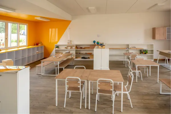 A bright Preschool classroom with a yellow feature wall and child-sized furniture