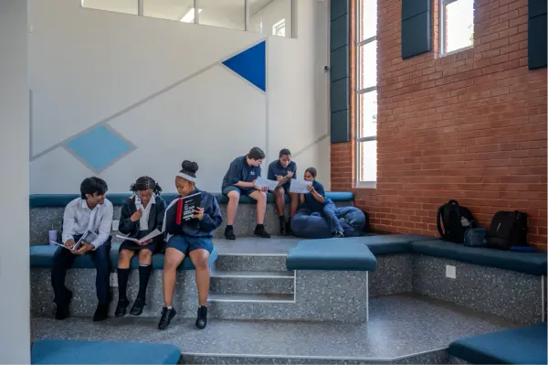High School students reading on the tiered seating in a collaborative space