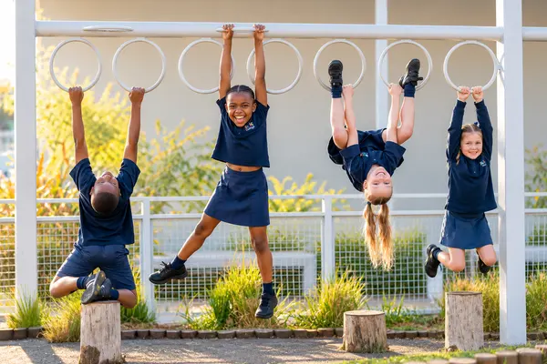 Prep children hanging and swinging on the monkey bars in the Prep play area