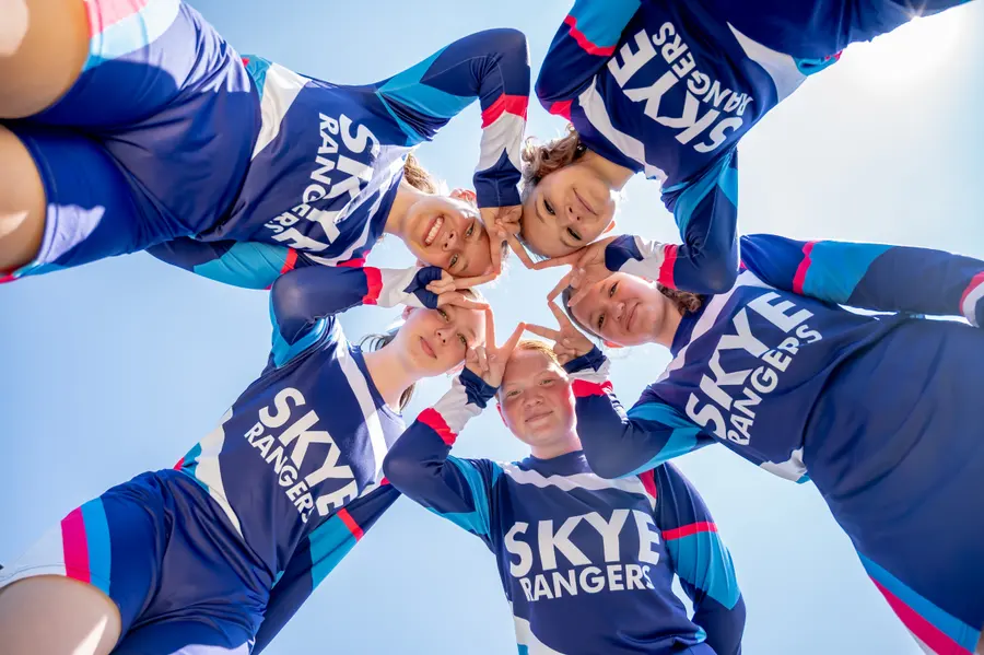 Skye Rangers cheerleaders smiling down into the camera in a huddle