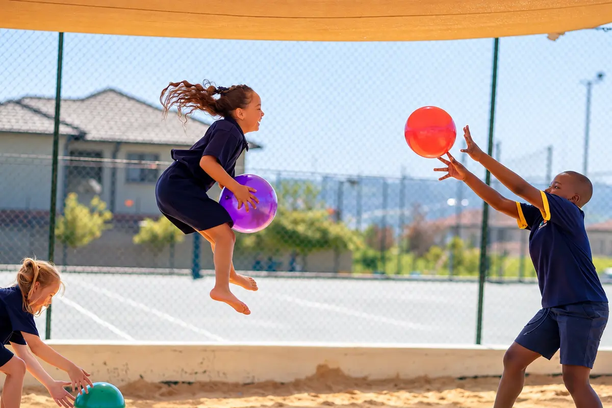 Prep children leaping for bright balls on the ball court