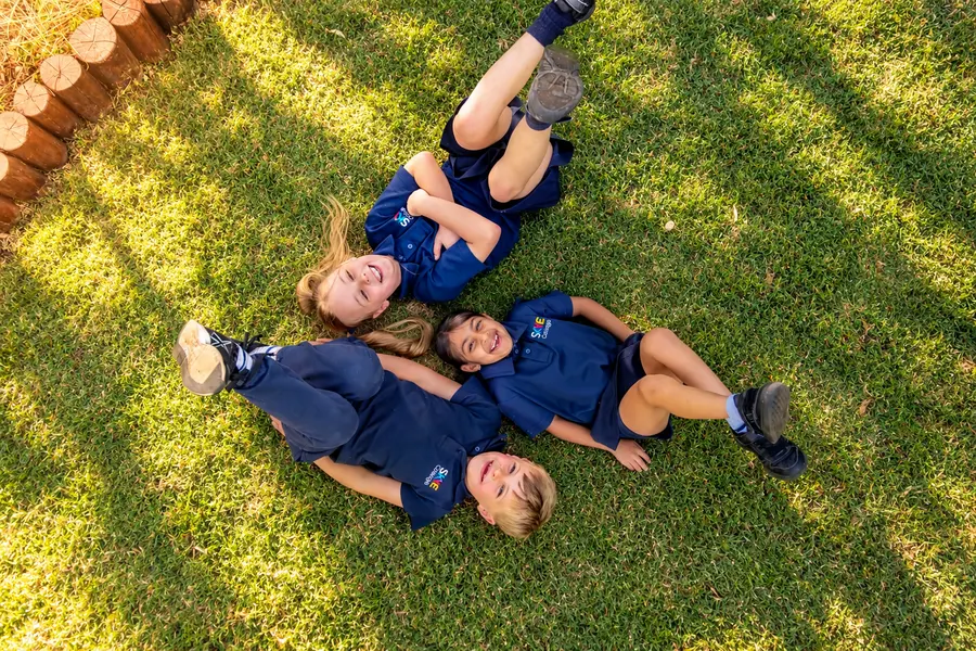 Prep friends lying in a star on the grass, laughing